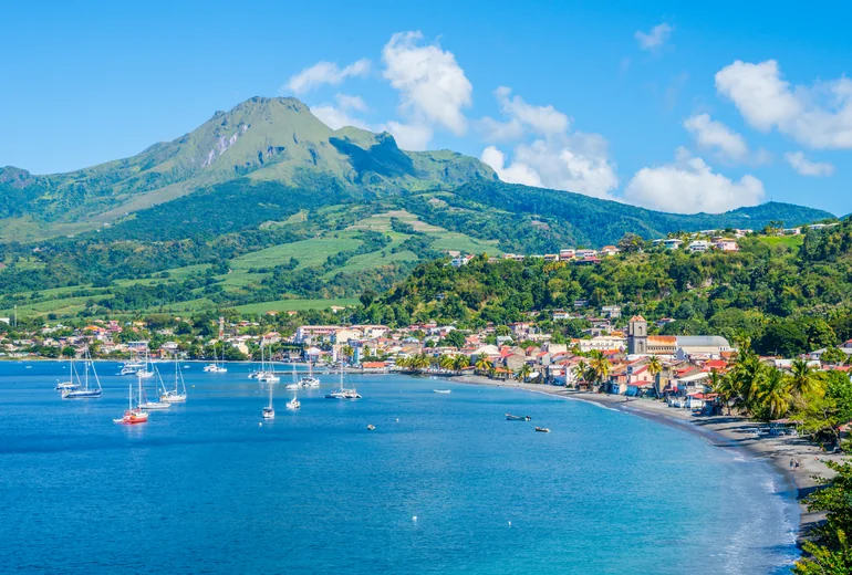 Anchored sailboats off a Caribbean town
