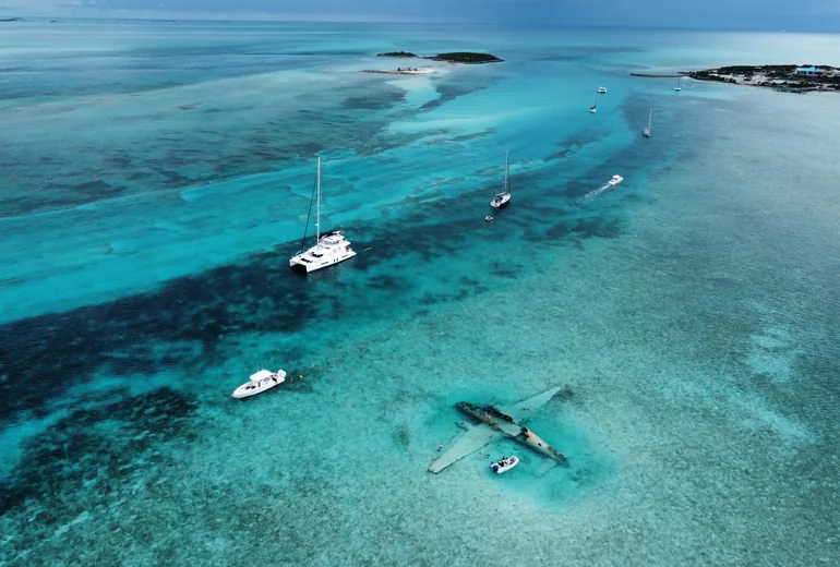 Catamaran at anchor over coral reef