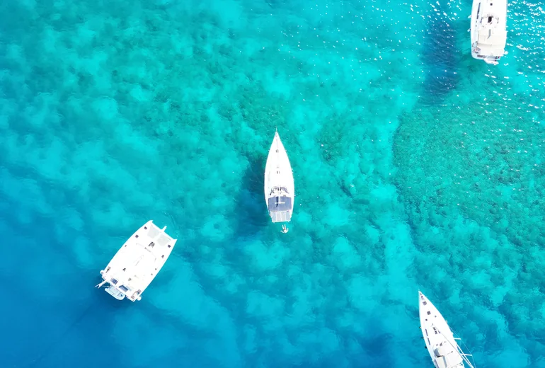 Sailboats anchored in Caribbean bay at evening