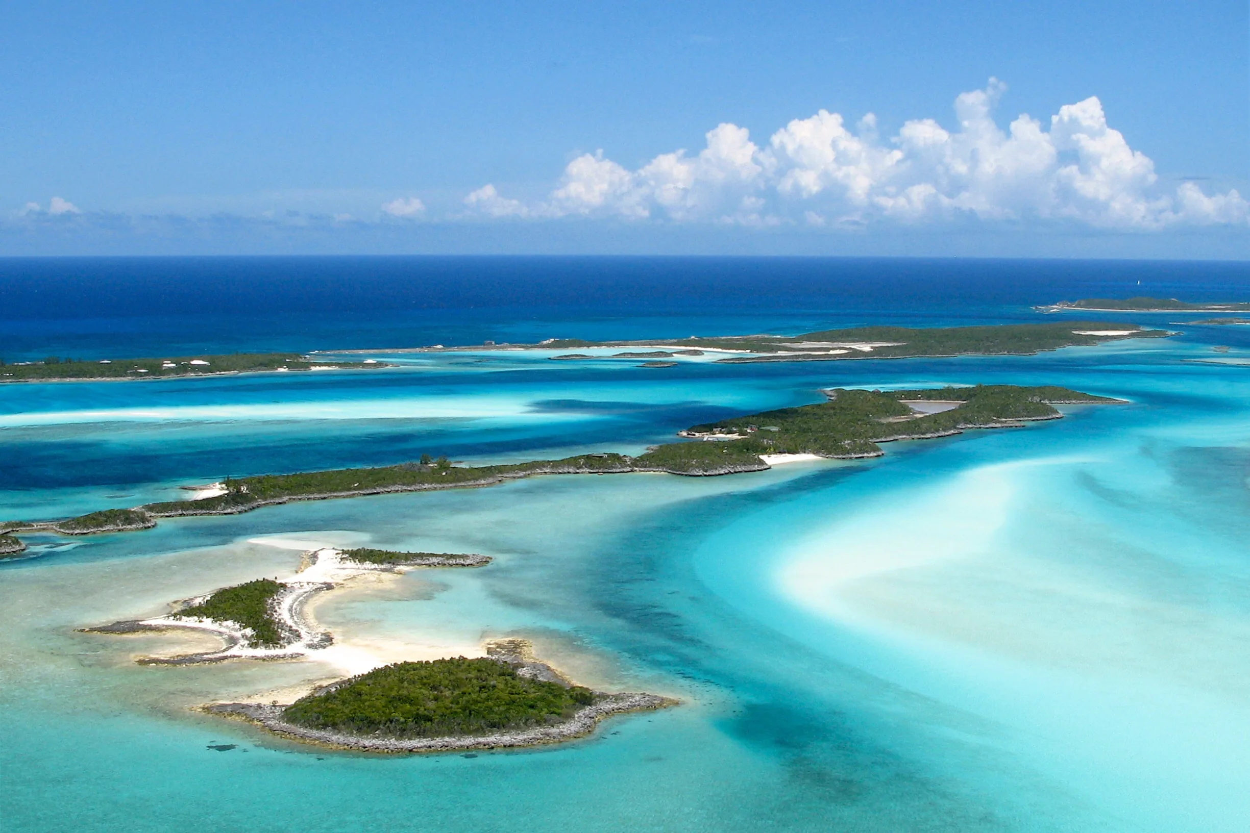 Aerial of scattered low green cays and white sandbars, Exuma Cays, Bahamas