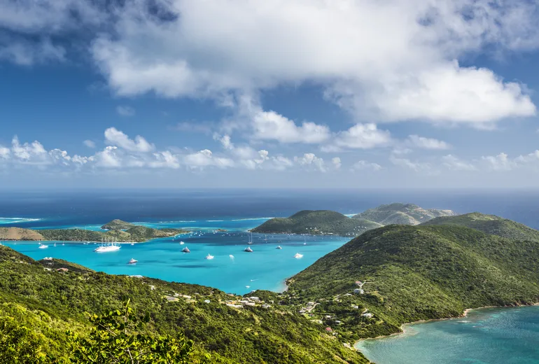 Panoramic hilltop view over green headlands and a yacht anchorage in the Virgin Gorda area, BVI